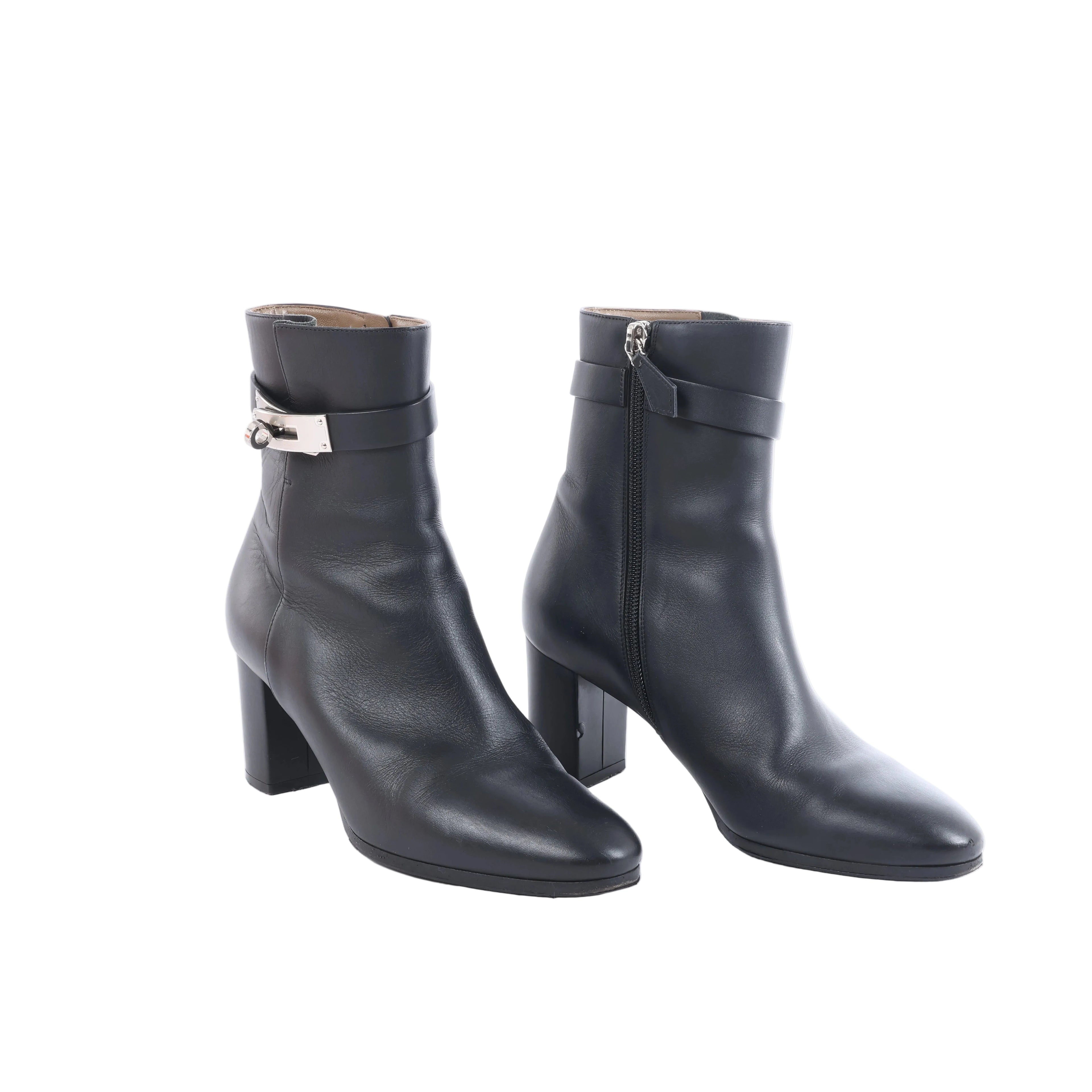 Black Hermès leather ankle boots with block heels and silver-tone Kelly buckle hardware displayed on a white background.