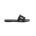 Black Hermès Aloha rubber slide sandal with sculpted cutout upper, flat sole and open-toe silhouette.