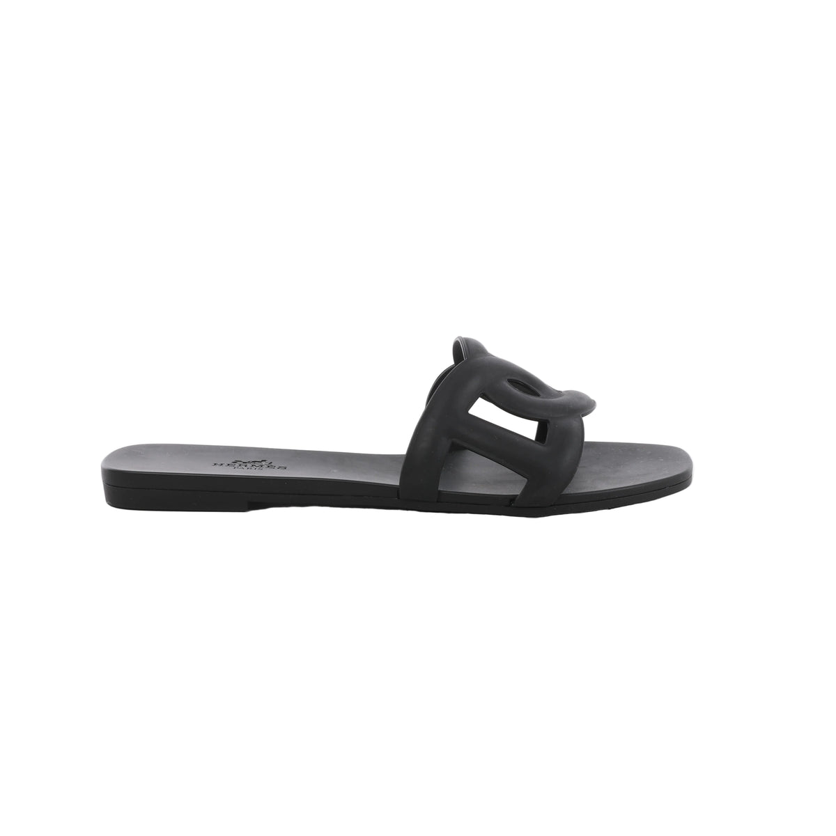 Black Hermès Aloha rubber slide sandal with sculpted cutout upper, flat sole and open-toe silhouette.