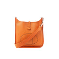Hermès Evelyne I 29 PM orange Epsom leather shoulder bag with perforated H logo, adjustable canvas strap, and silver-tone hardware, shown on white background