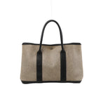 Beige Hermès Garden Party 36 PM canvas tote with dark brown leather handles and trim, vertical leather panels and silver-tone snap closure.