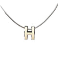 Close-up of a Hermès Pop H Necklace featuring an ecru enamel "H" pendant on a sleek silver chain, combining minimalist elegance with signature Hermès style.