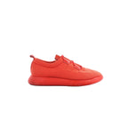 Red Hermès Teams sneaker in mesh with leather strap details, round toe, and thick red rubber sole on white background