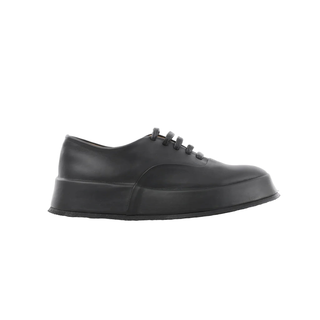 Black Jil Sander leather lace-up sneaker with smooth upper, tonal laces, and thick platform-style rubber sole, shown in side profile.