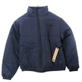 Navy blue Ksubi Sott puffer jacket with high padded collar, zip front, side pockets, elastic hem and cuffs, tonal chest logo, and hanging tag on white background.