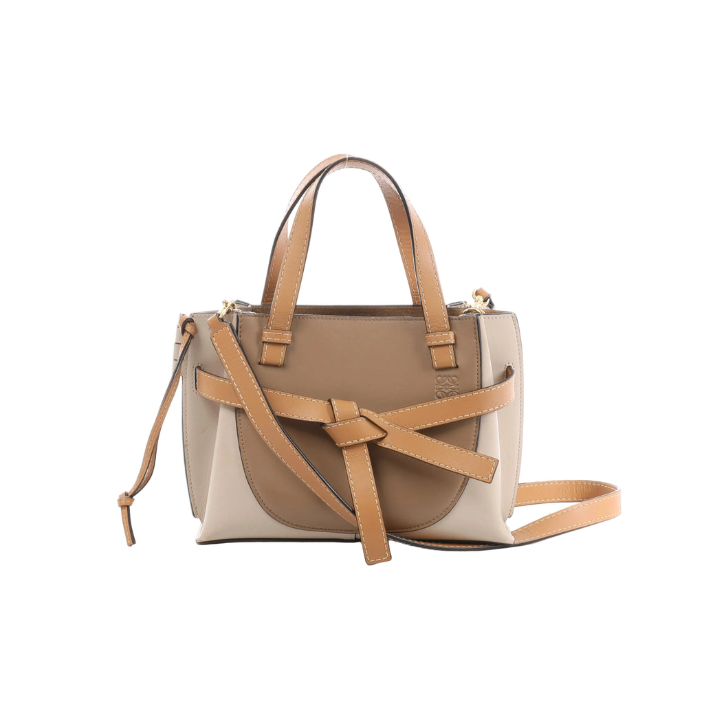 Beige and tan LOEWE Gate Mini leather handbag with top handles, knotted front strap, shoulder strap and gold-tone hardware.