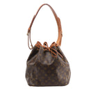 Brown Louis Vuitton Petit Noé Monogram canvas bucket bag with tan leather trim, drawstring closure, gold-tone eyelets and shoulder strap.