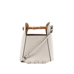 White leather LOEWE bucket handbag with bamboo top handle, detachable shoulder strap, black edge trim, and embossed logo on front.