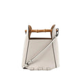 White leather LOEWE bucket handbag with bamboo top handle, detachable shoulder strap, black edge trim, and embossed logo on front.