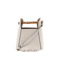 White leather LOEWE bucket handbag with bamboo top handle, detachable shoulder strap, black edge trim, and embossed logo on front.