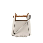White leather LOEWE bucket handbag with bamboo top handle, detachable shoulder strap, black edge trim, and embossed logo on front.