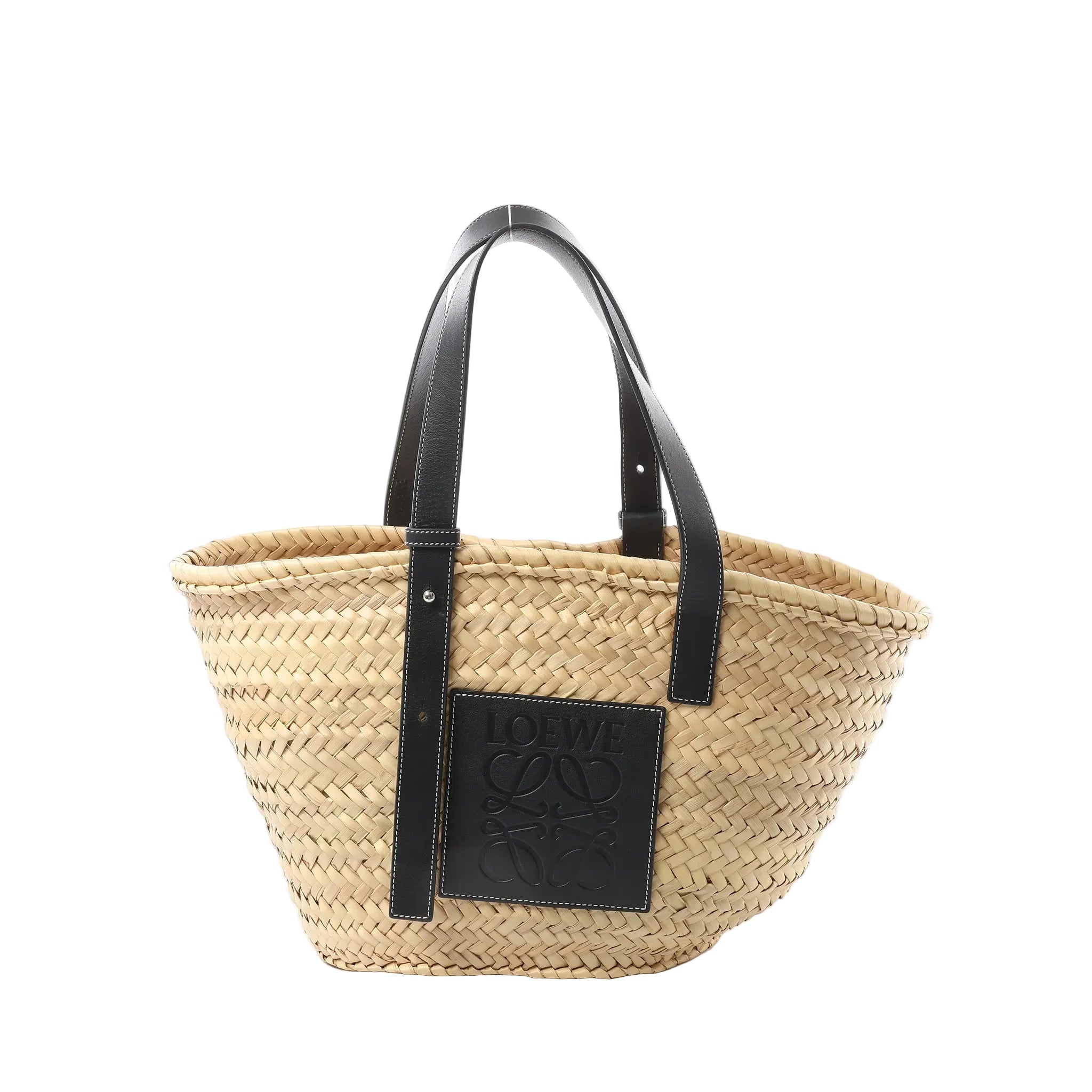 LOEWE Medium Basket bag in beige woven raffia with black leather shoulder straps and a black leather LOEWE logo patch on the front.