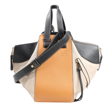 LOEWE Hammock Small 2Way Handbag in tricolor leather—orange front panel, black handles and strap, beige and black side panels, with zippered gussets and gold-tone hardware, displayed on a white background.