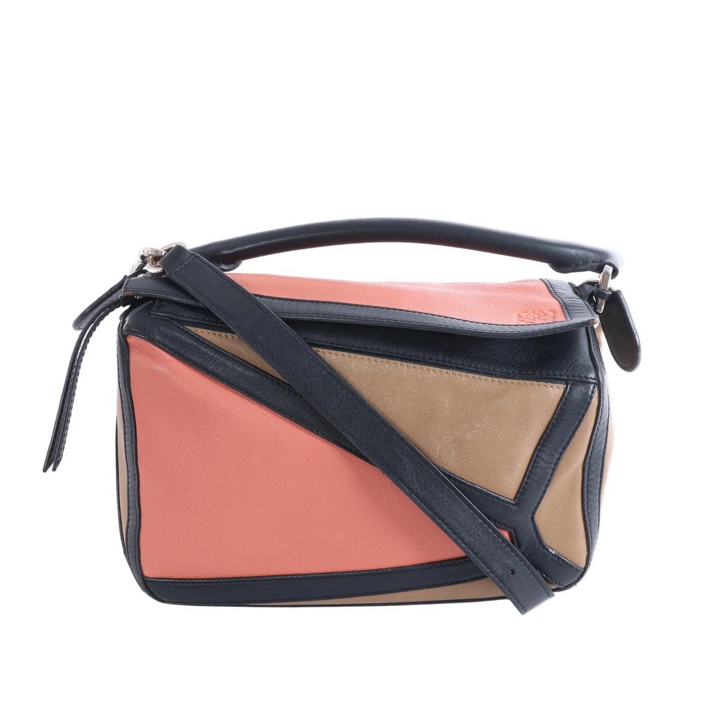 Small Loewe Puzzle bag in black, coral pink and tan leather with geometric panels, a top handle and detachable shoulder strap.