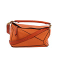 Orange LOEWE Puzzle Medium leather handbag with geometric paneling, top handle, adjustable shoulder strap and gold-tone hardware.