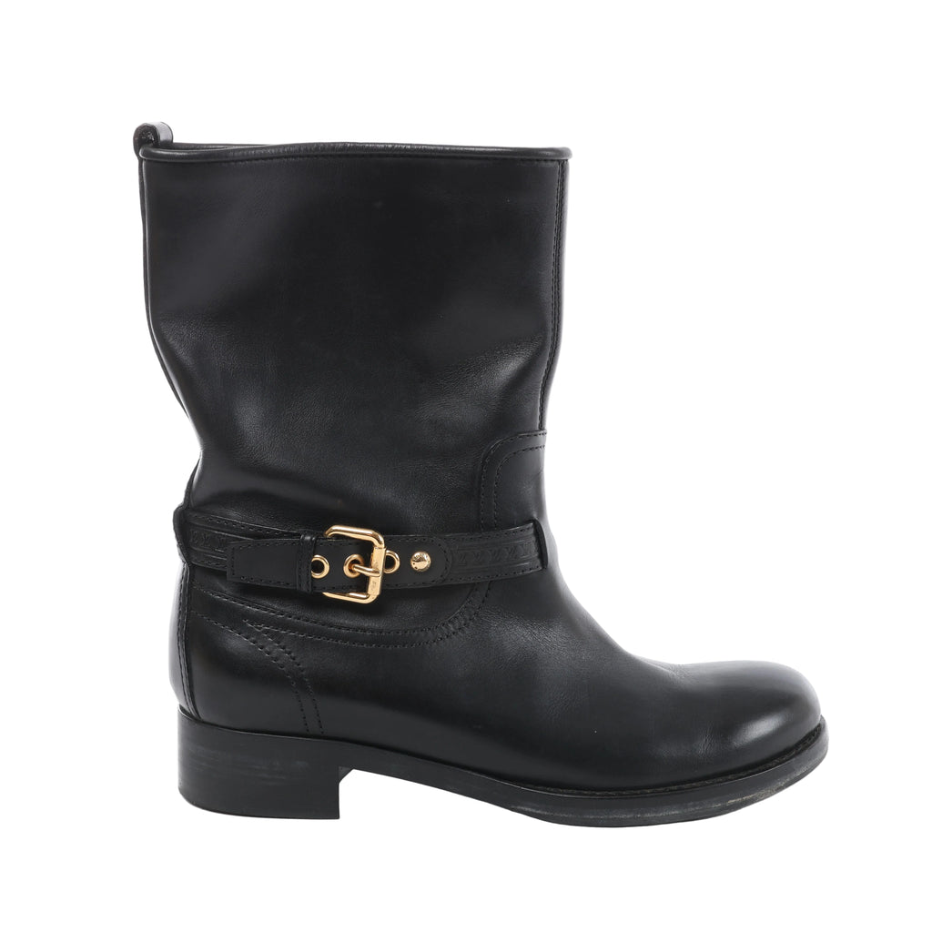 Side view of a black Louis Vuitton Susan leather boot with a rounded toe, low block heel and embossed ankle strap with a gold-tone buckle.