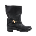 Side view of a black Louis Vuitton Susan leather boot with a rounded toe, low block heel and embossed ankle strap with a gold-tone buckle.