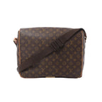 Louis Vuitton Monogram canvas Abbesses messenger bag with wide adjustable brown shoulder strap and vachetta trim on white background.