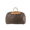 Louis Vuitton Alize Monogram canvas travel bag in brown with tan vachetta leather top handles, leather trim, and top zip closure, front view on white background.