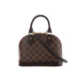 Brown Louis Vuitton Alma BB handbag in Damier Ebene checkered canvas with dark leather handles, detachable shoulder strap and gold-tone hardware.