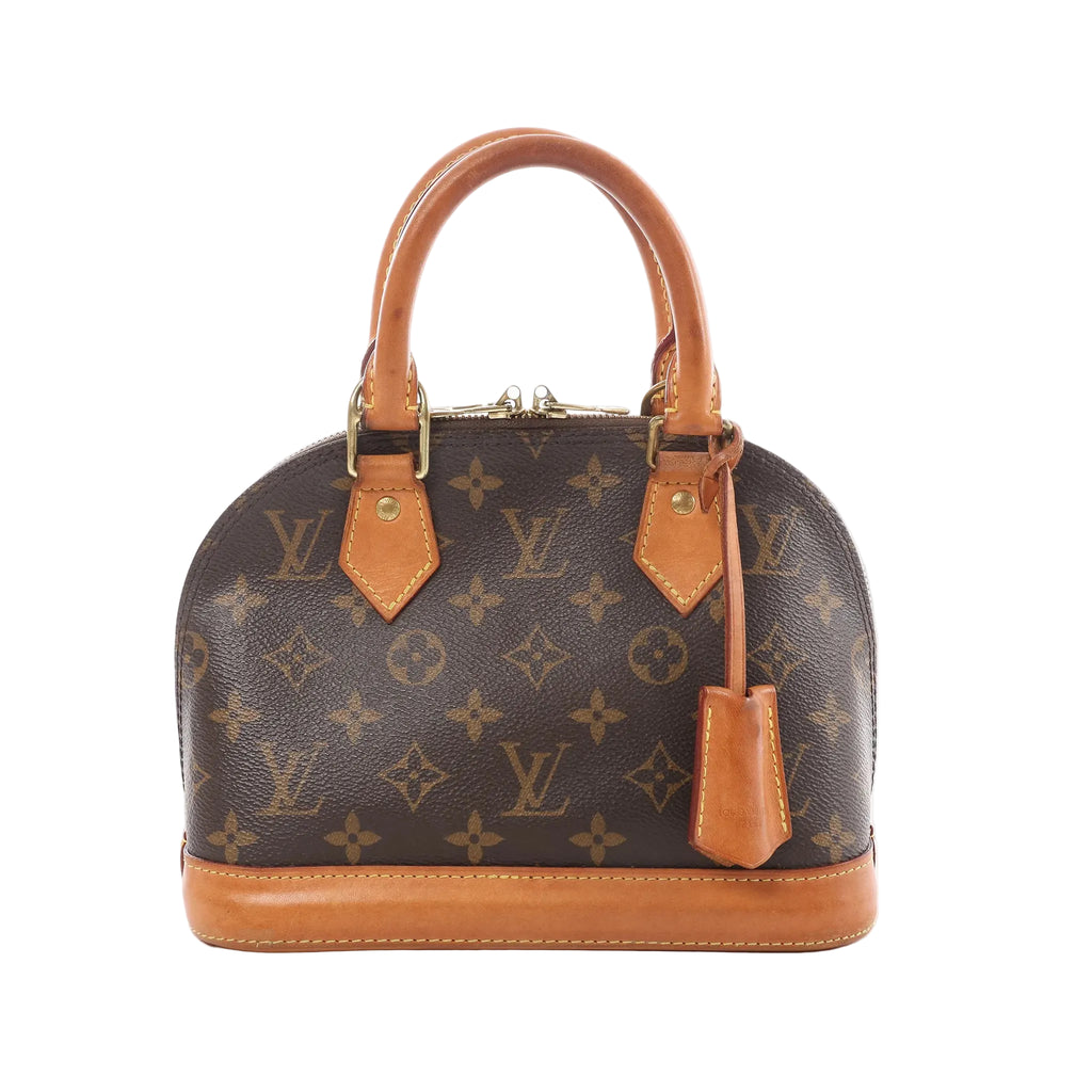 Louis Vuitton Alma BB brown Monogram canvas handbag with tan leather top handles, leather base trim, and hanging leather clochette, front view on white background.