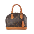 Louis Vuitton Alma BB brown Monogram canvas handbag with tan leather top handles, leather base trim, and hanging leather clochette, front view on white background.