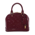 Louis Vuitton Alma BB handbag in glossy purple Monogram Vernis leather with dual top handles, gold-tone hardware, and hanging key clochette on white background