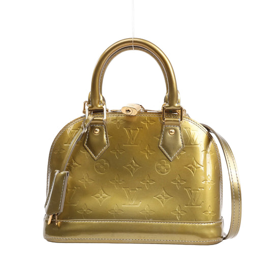 Louis Vuitton Alma BB 2Way handbag in metallic gold Monogram Vernis leather featuring embossed LV monogram, dual top handles, a detachable shoulder strap, and gold-tone hardware.