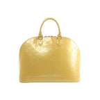 Yellow Louis Vuitton Alma GM Vernis patent leather handbag with embossed Monogram pattern, double top handles, and zip-top closure, front view on white background.