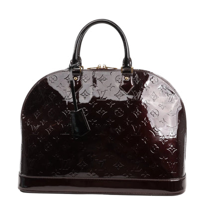 Louis Vuitton Alma GM M93595 handbag in deep Amarante Monogram Vernis patent leather featuring a structured dome shape, rolled leather handles, gold-tone hardware, and key bell accessory.