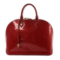 Louis Vuitton Alma GM handbag in glossy red Vernis patent leather with embossed Monogram, top handles, zip closure, and hanging clochette key on a white background.