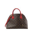Louis Vuitton Alma B'N'B brown Monogram canvas handbag with red leather top handles, red shoulder strap, and gold-tone hardware on a white background