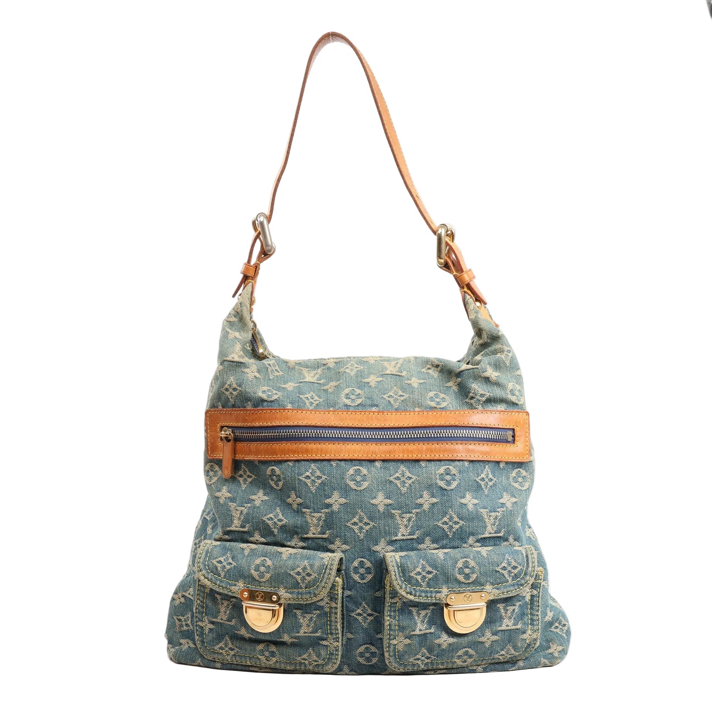 Louis Vuitton Baggy GM shoulder bag in blue Monogram denim featuring natural leather trim, a zip-top closure, two front flap pockets with gold-tone clasps, and a single adjustable leather shoulder strap.