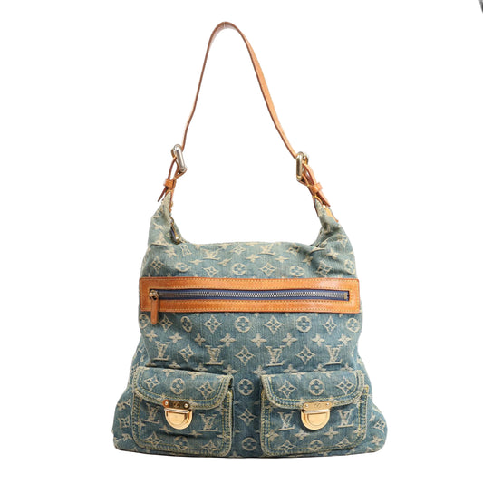 Louis Vuitton Baggy GM shoulder bag in blue Monogram denim featuring natural leather trim, a zip-top closure, two front flap pockets with gold-tone clasps, and a single adjustable leather shoulder strap.