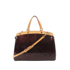 Louis Vuitton Blair MM Vernis handbag in dark burgundy patent with embossed Monogram, natural leather top handles and trim, and an adjustable shoulder strap.