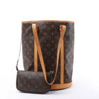 Angled front view of a brown Louis Vuitton Bucket GM Monogram canvas shoulder bag with tan leather trim, long straps and a matching zip pouch.
