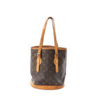 Louis Vuitton Monogram canvas Bucket PM shoulder bag with tan vachetta leather trim, adjustable leather shoulder straps, and vachetta leather base