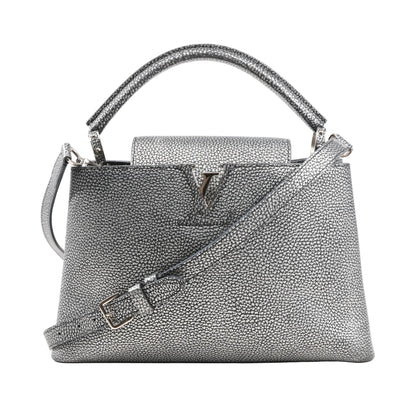Louis Vuitton Capucines PM 2Way handbag in metallic silver Taurillon leather featuring a structured shape, top handle, detachable shoulder strap, and LV logo hardware on the front flap.