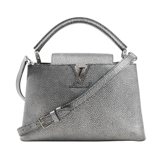 Louis Vuitton Capucines PM 2Way handbag in metallic silver Taurillon leather featuring a structured shape, top handle, detachable shoulder strap, and LV logo hardware on the front flap.