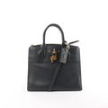 Louis Vuitton City Steamer PM black leather handbag with top handles, detachable shoulder strap, zip-top closure, LV luggage tag, and gold-tone padlock on white background