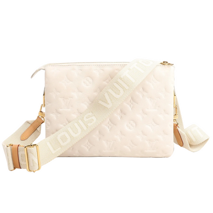 Louis Vuitton Coussin PM M57793 crossbody bag in white puffy Monogram-embossed lambskin with wide ivory logo strap and gold-tone hardware.