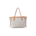 Louis Vuitton Neverfull PM shoulder bag in beige and white Damier Azur canvas with tan vachetta leather trim, slim straps, side ties, and gold-tone hardware on white background.