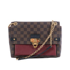 Louis Vuitton Vavin PM bag in brown Damier Ebene canvas with burgundy leather pocket, gold-tone clasp and chain strap.