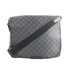 Louis Vuitton Daniel MM crossbody bag in black Damier Graphite canvas with flap front, black trim, and adjustable black shoulder strap.