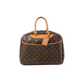 Louis Vuitton Deauville handbag in brown Monogram canvas with tan vachetta leather top handles and trim, gold-tone hardware, and hanging leather tag on a white background.