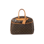 Louis Vuitton Deauville handbag in brown Monogram canvas with tan vachetta leather top handles and trim, gold-tone hardware, and hanging leather tag on a white background.