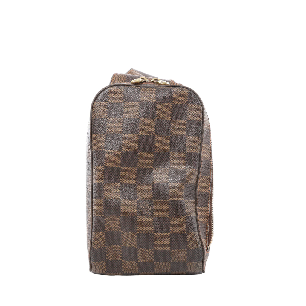 Brown Louis Vuitton Geronimos Damier Ebene bag with a checkerboard pattern, rounded rectangular shape, dark leather piping and two gold-tone zip pulls.