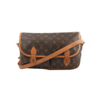 Louis Vuitton Gibecière MM crossbody bag in brown Monogram canvas with tan leather trim, flap front, and long shoulder strap on white background