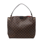 Brown Louis Vuitton Graceful PM Damier Ebene shoulder bag with dark leather strap, gold-tone eyelets and a glimpse of red lining.