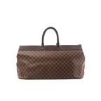 Louis Vuitton Greenwich GM Damier Ebene bag with brown check canvas, dark leather top handles, and zip-top closure, front view on a white background.